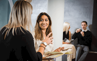 Two women chatting during a meeting