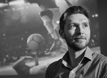 Dr Dan kilvington with image of footballer on backdrop