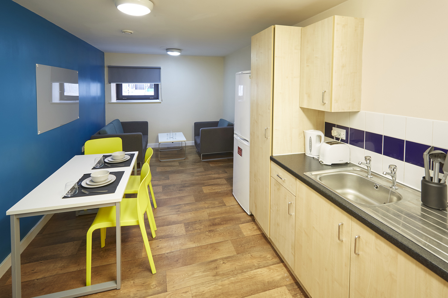 Spacious kitchen with three seater table, sink and fridge