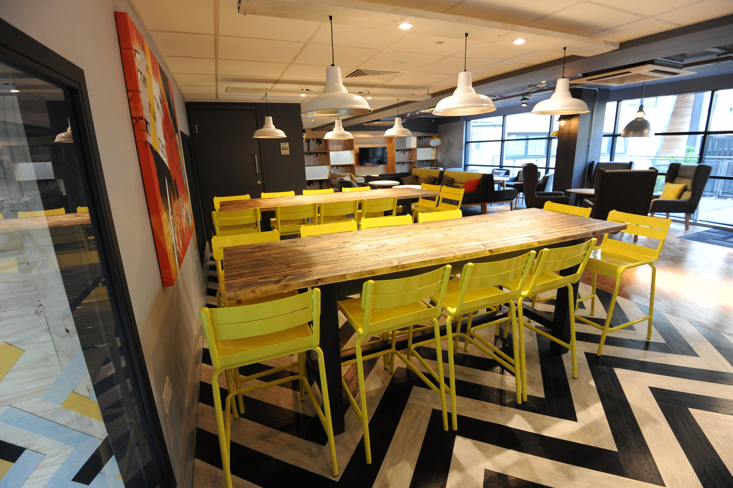 Large table of 9 with bright yellow chairs and zig zag carpet