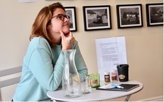 Caitlin Gormons at at table in blue sweater