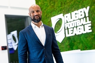 Man in suit standing in front of Rugby Football League