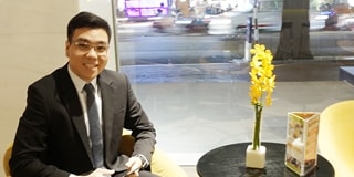 Dark haired man sat in hotel lobby