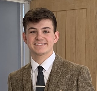 Ewan wearing brown suit and tie