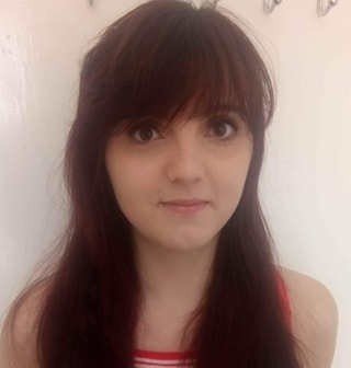 Girl with long, dark brown hair looking at the camera