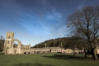 an abbey ruin with a striking blue sky above