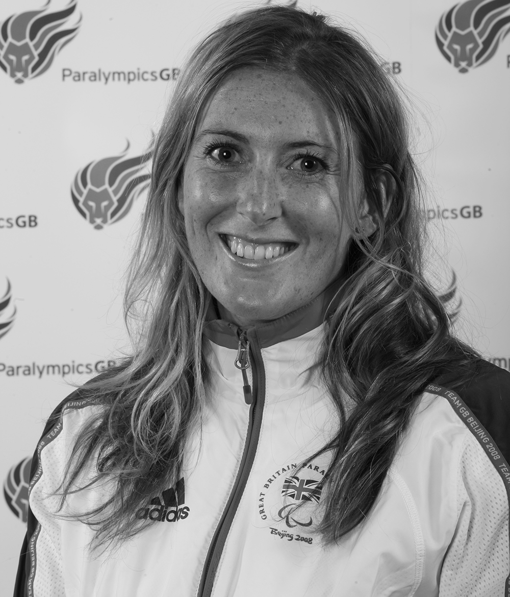 Black and white photograph of Victoria Aggar in front of the ParalympicsGB logo