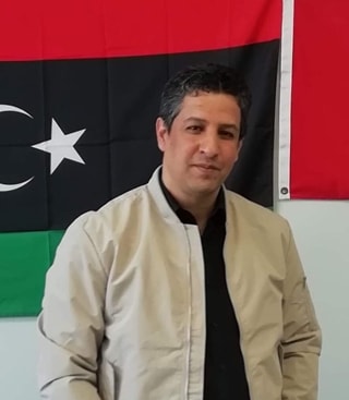 Wanees in front of the Libya flag