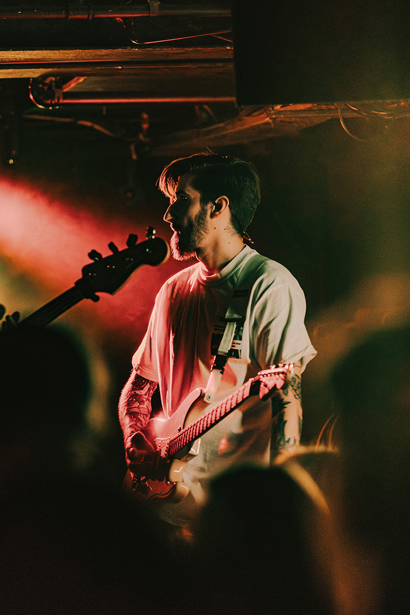 Cameron Hughes holding guitar performing