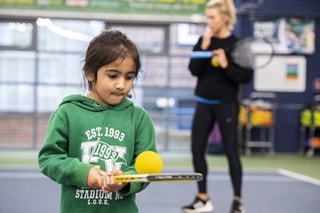 Image of young girl partaking in tennis summer camp