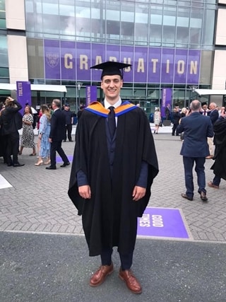 Man in gown at graduation event