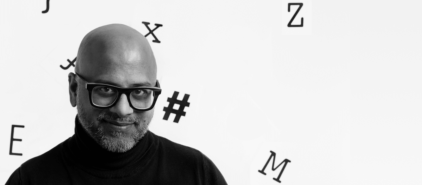 Dr nasser Hussain with random latters and symbols on a backdrop